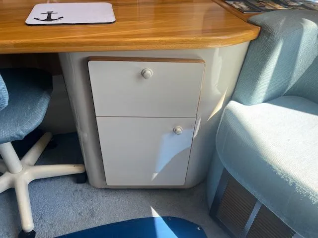 Papa's 7 II Yacht Photos Pics Interior of 1995 Sea Ray 440 Express Bridge with wooden desk and cushioned seating.