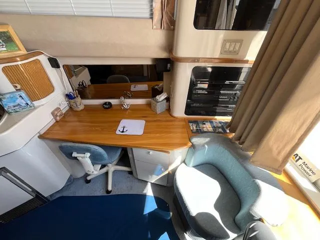 Papa's 7 II Yacht Photos Pics Interior of 1995 Sea Ray 440 Express Bridge with desk, chair, and seating area.