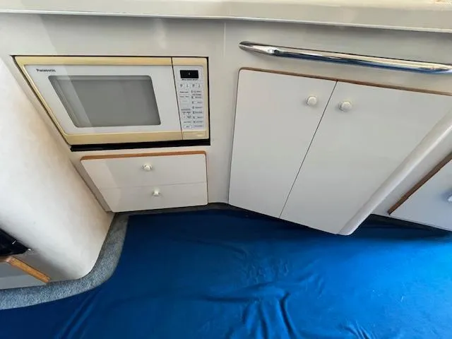 Papa's 7 II Yacht Photos Pics Interior of 1995 Sea Ray 440 Express Bridge with microwave and cabinetry.
