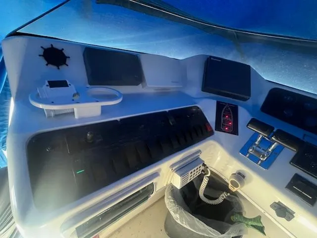 Papa's 7 II Yacht Photos Pics 1995 Sea Ray 440 Express Bridge helm with navigation controls and instruments under blue cover.