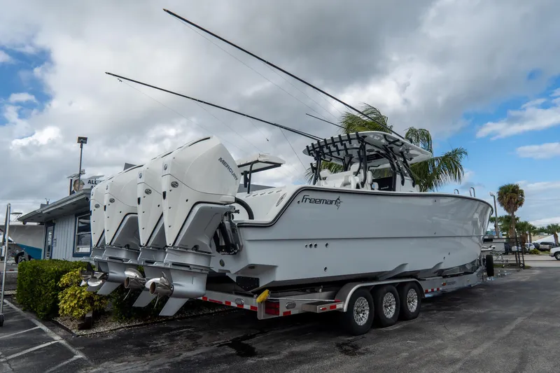  Yacht Photos Pics 2024 Freeman 38 boat with triple Mercury engines on a trailer, parked outdoors.