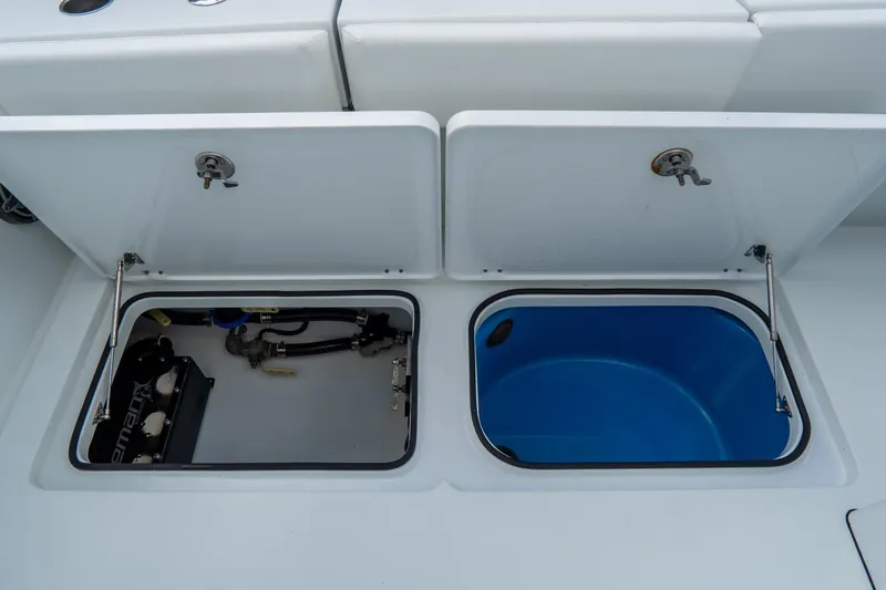  Yacht Photos Pics Open storage compartments on a 2024 Freeman 38 boat, featuring equipment and a blue container.