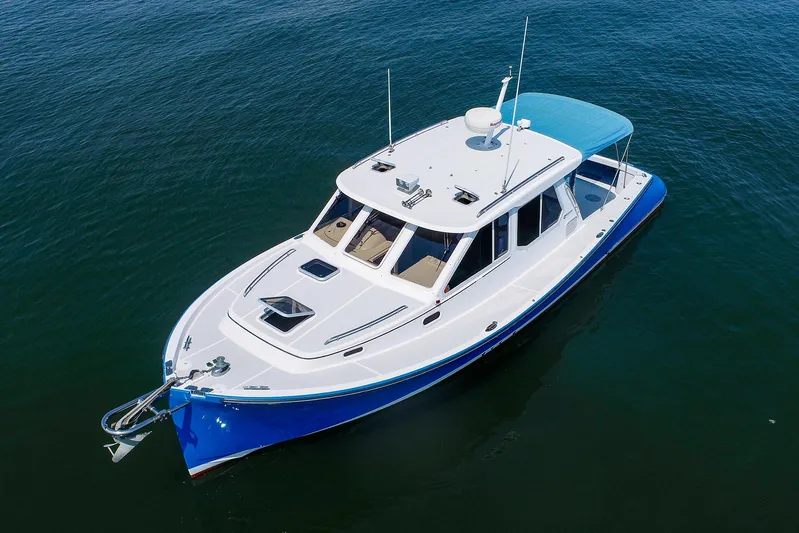  Yacht Photos Pics 2004 True North 38 yacht with blue hull on calm water.