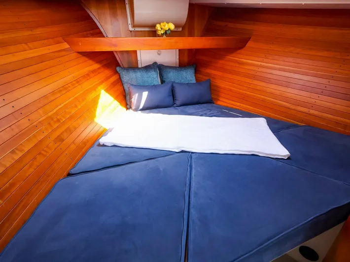  Yacht Photos Pics Cozy cabin interior of 2004 True North 38 boat with wooden walls and blue bedding.
