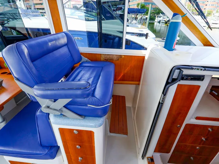  Yacht Photos Pics Captain's chair on 2004 True North 38 boat, featuring blue upholstery and wooden accents.