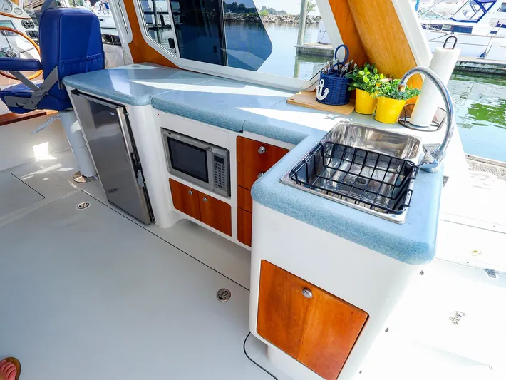 Yacht Photos Pics Luxurious 2004 True North 38 yacht kitchen with sink, microwave, and seating.