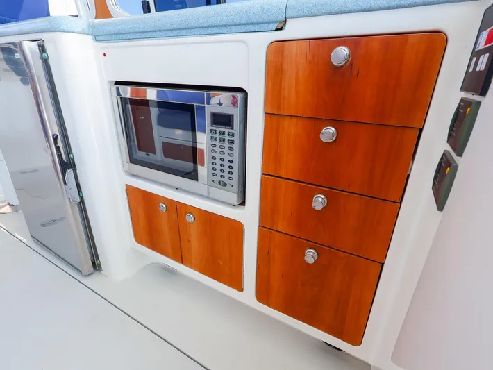  Yacht Photos Pics Modern yacht kitchen with microwave, wooden cabinets, and stainless steel fridge. True North 38, 2004 model.