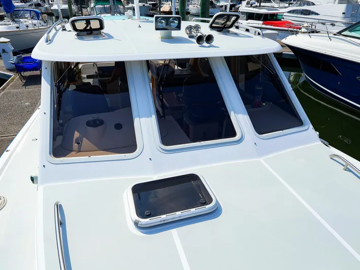  Yacht Photos Pics 2004 True North 38 boat docked, showcasing sleek design and spacious cabin windows.