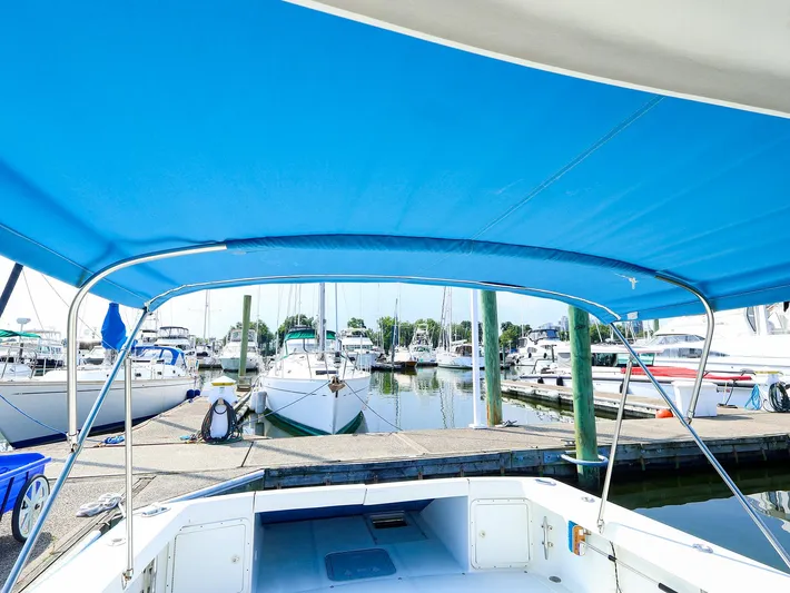  Yacht Photos Pics 2004 True North 38 boat with blue canopy docked at marina.