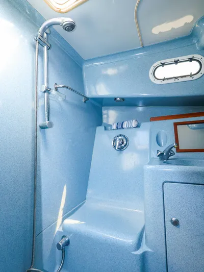  Yacht Photos Pics Compact blue bathroom in 2004 True North 38 boat, featuring shower and sink.