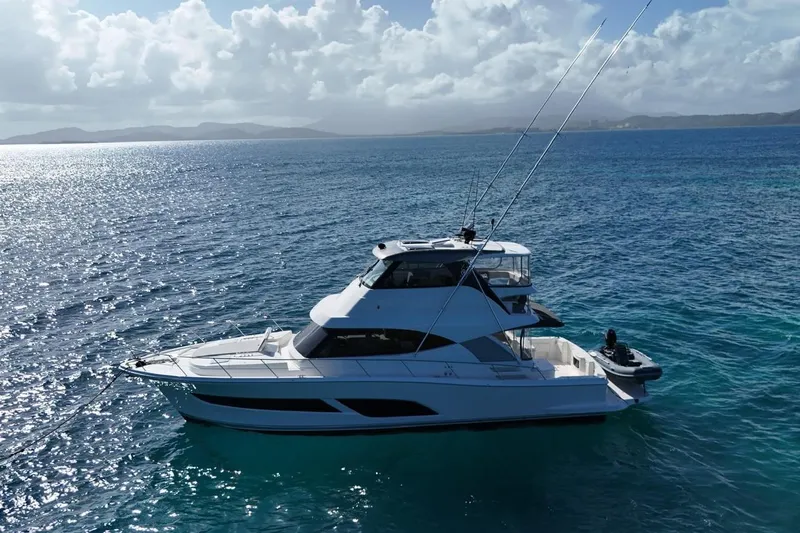  Yacht Photos Pics 2021 Riviera 50 Sports Motor Yacht cruising on clear blue ocean waters.