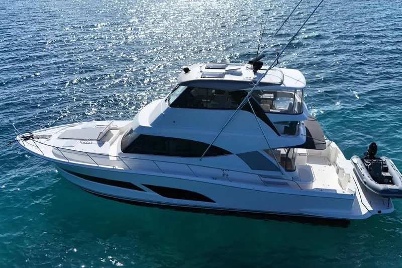  Yacht Photos Pics 2021 Riviera 50 Sports Motor Yacht cruising on clear blue water.