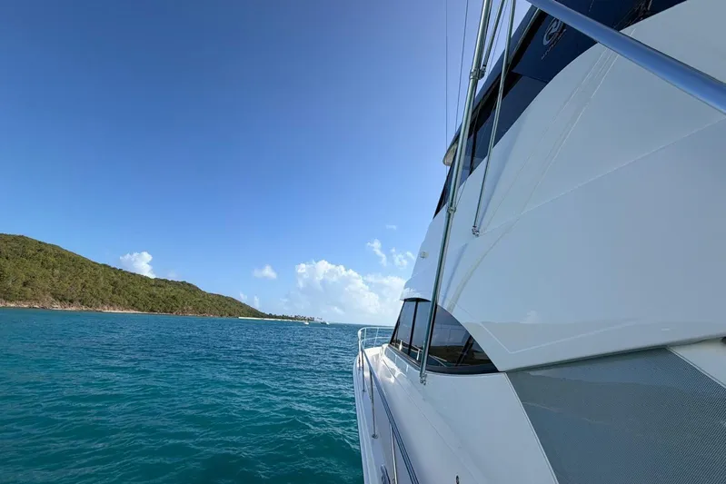  Yacht Photos Pics 2021 Riviera 50 Sports Motor Yacht cruising near a scenic coastline.