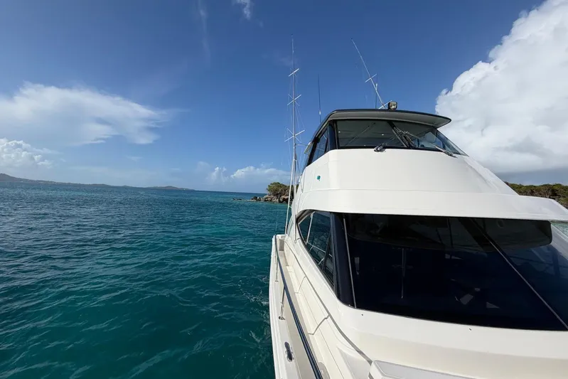  Yacht Photos Pics 2021 Riviera 50 Sports Motor Yacht cruising on clear blue waters.