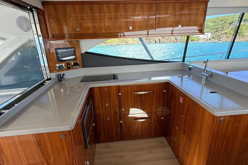  Yacht Photos Pics Luxurious kitchen interior of 2021 Riviera 50 Sports Motor Yacht with wood cabinetry and ocean view.