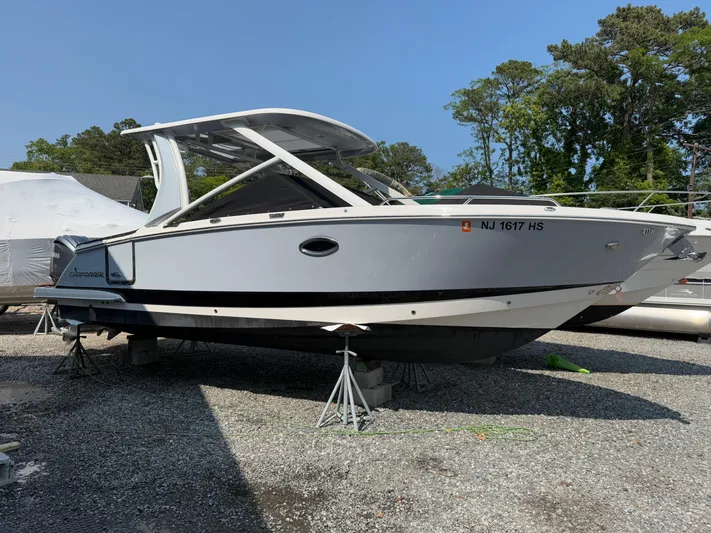  Yacht Photos Pics 2023 Chaparral 280 OSX boat on stands, parked outdoors on gravel.