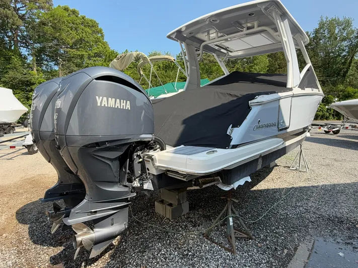  Yacht Photos Pics 2023 Chaparral 280 OSX boat with Yamaha engines, parked on gravel.