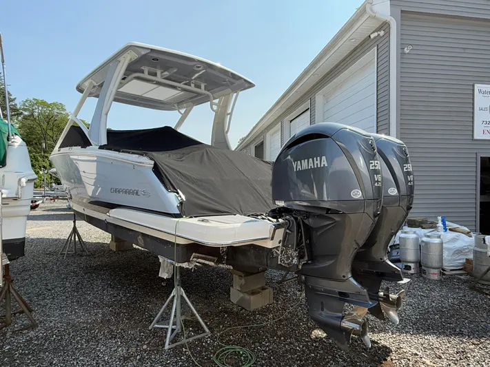  Yacht Photos Pics 2023 Chaparral 280 OSX boat with twin Yamaha engines, covered and elevated on stands.