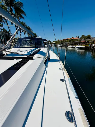 Freedom Yacht Photos Pics 2015 Beneteau Oceanis 55 sailboat docked by a serene waterfront.