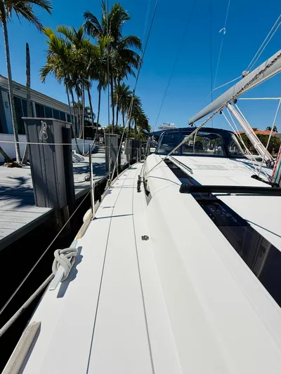 Freedom Yacht Photos Pics 2015 Beneteau Oceanis 55 sailboat docked, surrounded by palm trees under a clear blue sky.