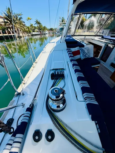 Freedom Yacht Photos Pics 2015 Beneteau Oceanis 55 sailboat deck with winch, docked in a scenic canal.