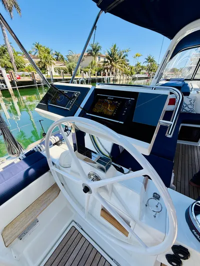 Freedom Yacht Photos Pics Beneteau Oceanis 55 yacht helm, 2015 model, with modern navigation equipment and scenic marina backdrop.