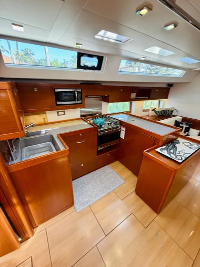 Freedom Yacht Photos Pics Interior of 2015 Beneteau Oceanis 55 yacht kitchen with modern appliances and wood finish.