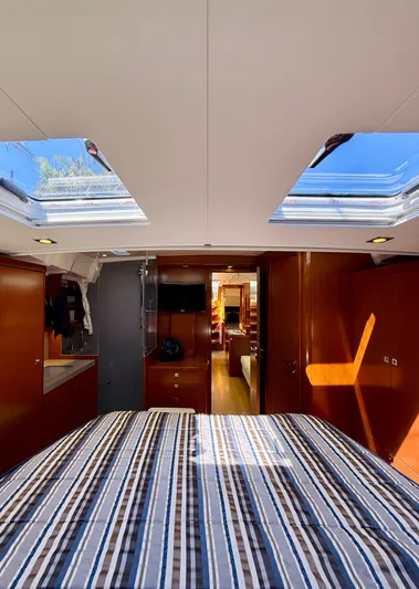 Freedom Yacht Photos Pics Interior of 2015 Beneteau Oceanis 55 yacht with skylights and striped bedding.