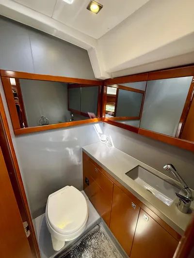 Freedom Yacht Photos Pics Luxurious bathroom in 2015 Beneteau Oceanis 55 yacht with modern fixtures and wood accents.