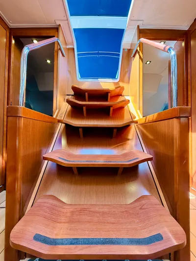 Freedom Yacht Photos Pics Interior staircase of 2015 Beneteau Oceanis 55 yacht with wooden steps and skylight.