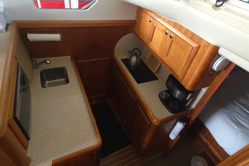 Nite Owl Yacht Photos Pics galley with sink, stove, and wooden cabinets