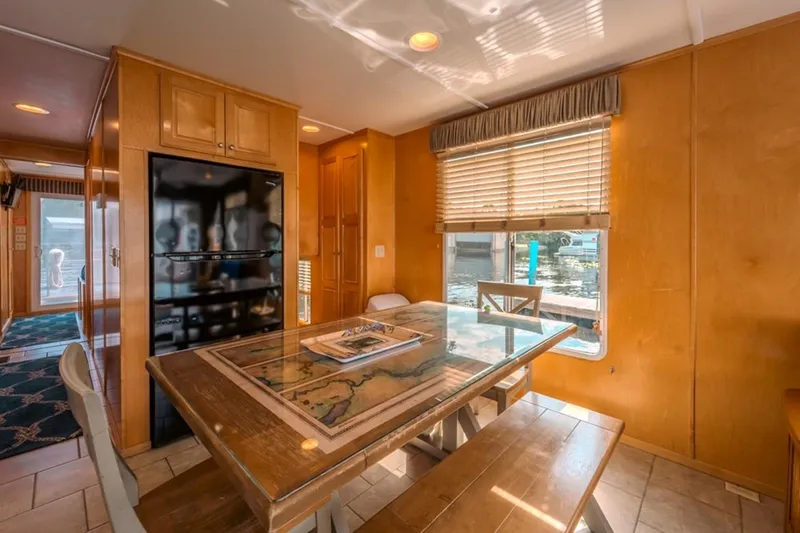 Southern Belle Yacht Photos Pics Dining area inside 2014 Sunstar Houseboats 55, featuring wooden table and window view.