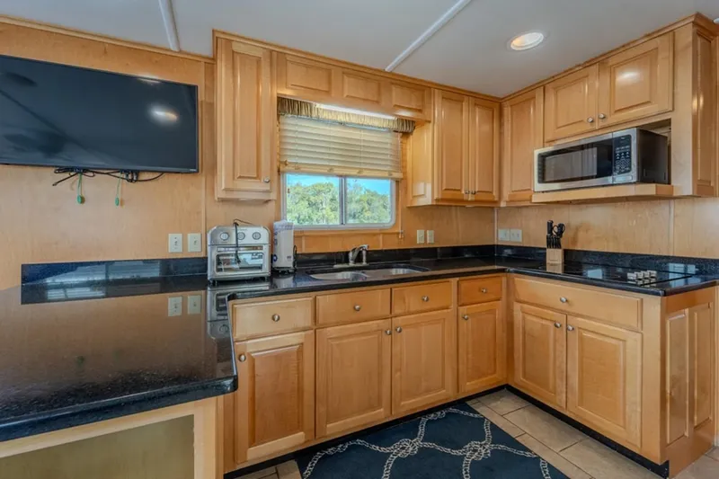 Southern Belle Yacht Photos Pics Modern kitchen in 2014 Sunstar Houseboats 55, featuring wood cabinets and black countertops.
