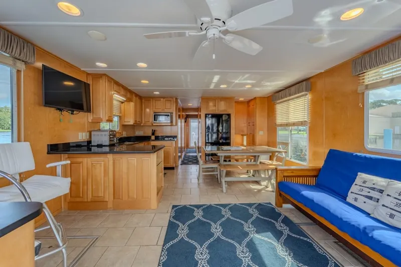 Southern Belle Yacht Photos Pics Interior of 2014 Sunstar Houseboats 55, featuring kitchen, dining area, and blue sofa.