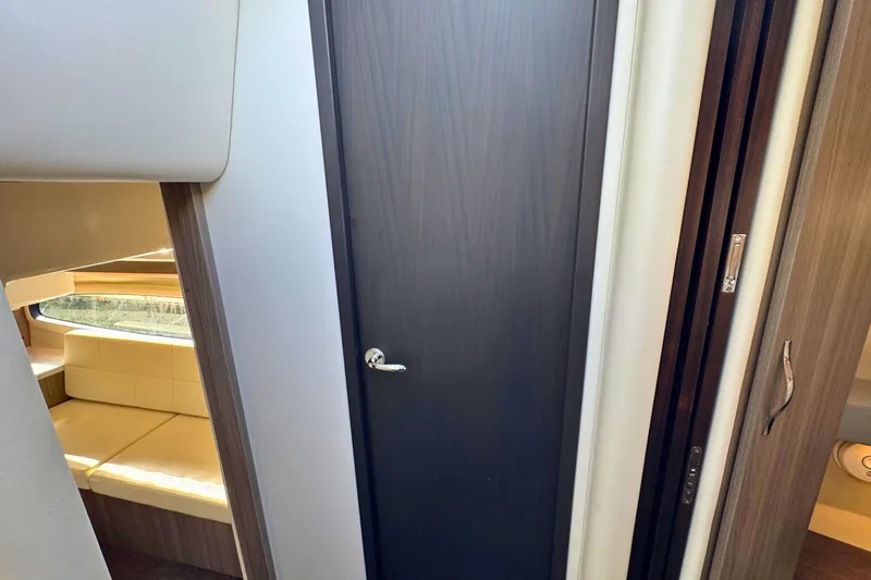  Yacht Photos Pics Interior of 2021 Regal 38 Grande Coupe, featuring sleek wood door and cozy seating area.