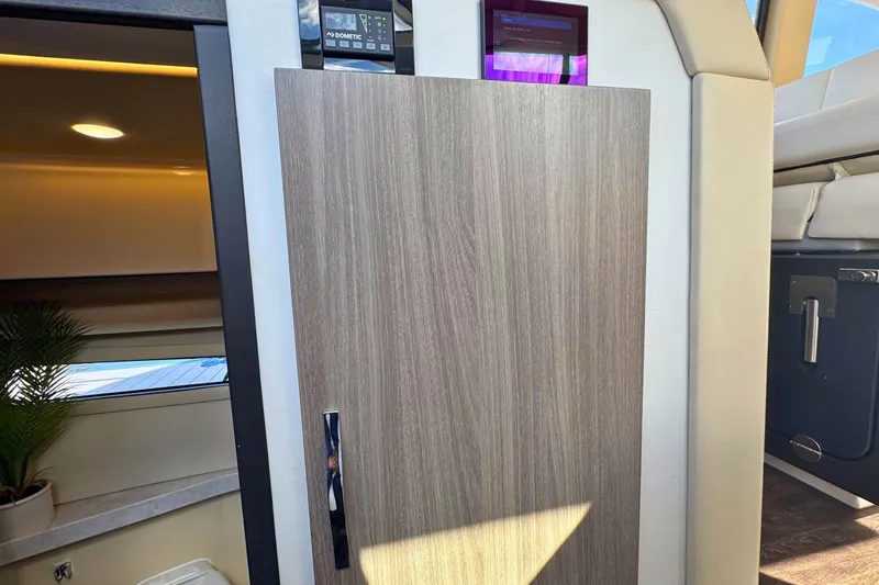  Yacht Photos Pics Interior of 2021 Regal 38 Grande Coupe yacht, featuring modern wood paneling and control panels.