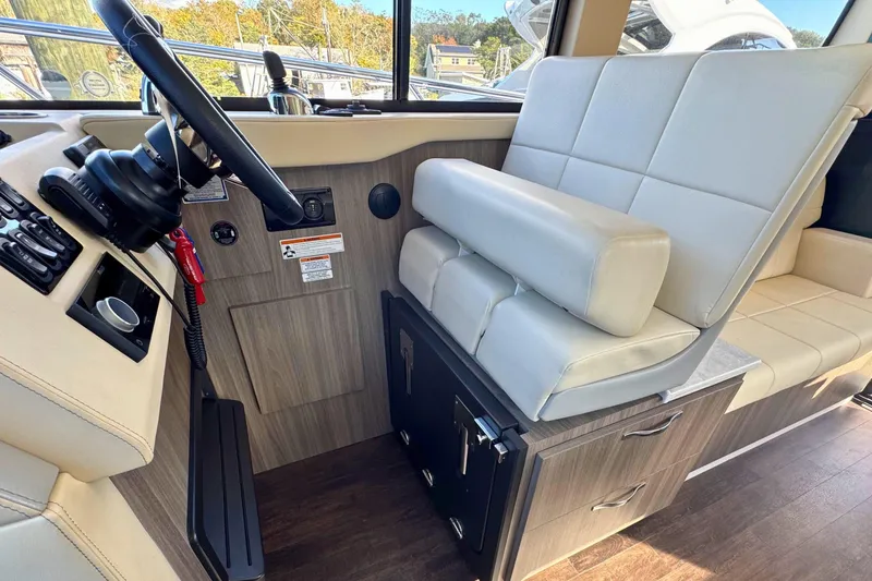  Yacht Photos Pics Interior of 2021 Regal 38 Grande Coupe with steering wheel and cushioned seating.