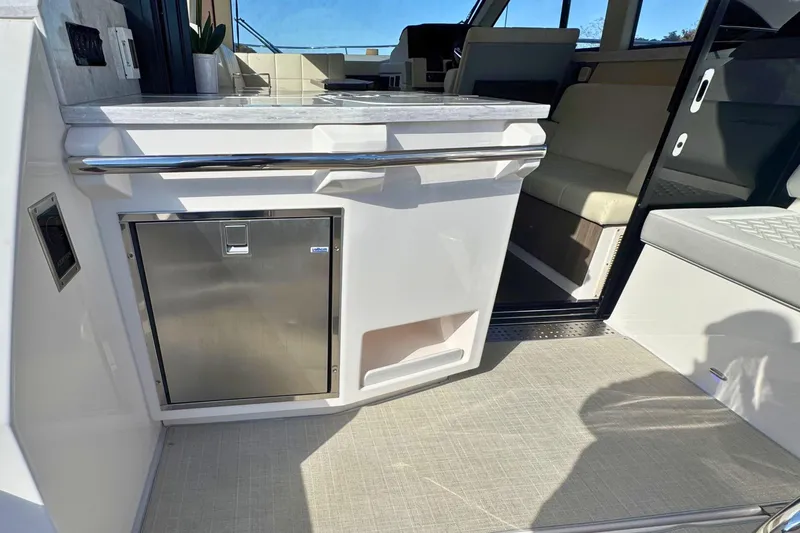  Yacht Photos Pics 2021 Regal 38 Grande Coupe interior with kitchenette and seating area.
