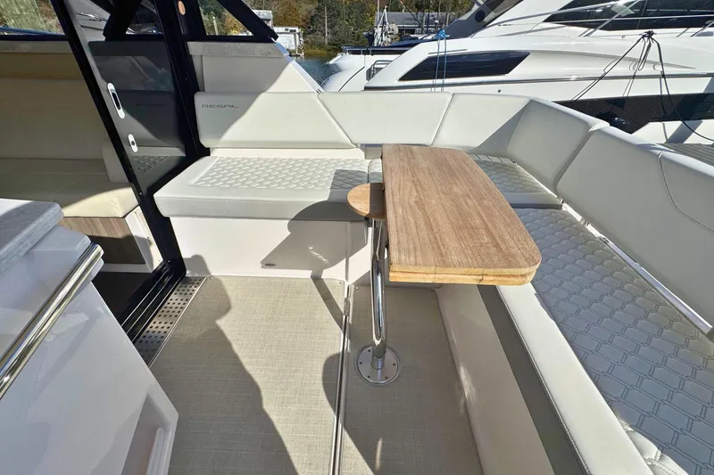  Yacht Photos Pics 2021 Regal 38 Grande Coupe interior with seating and wooden table.