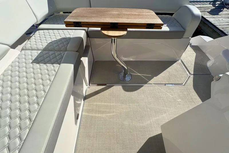  Yacht Photos Pics 2021 Regal 38 Grande Coupe interior with quilted seating and wooden table.
