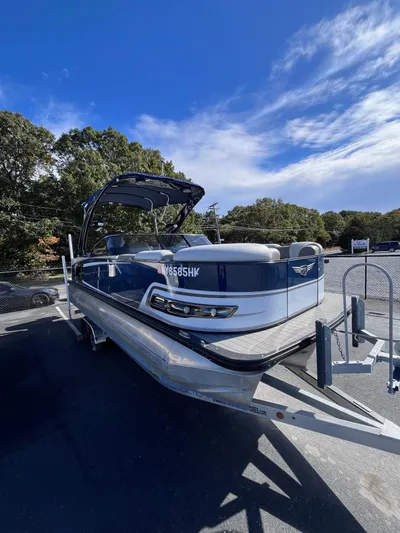  Yacht Photos Pics 2023 Avalon Excalibur Elite Windshield boat on trailer under clear blue sky.