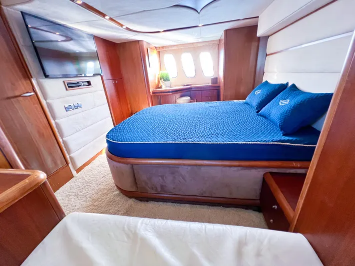  Yacht Photos Pics Luxurious 2005 Sunseeker Predator 68 yacht bedroom with blue bedding and elegant wood finishes.