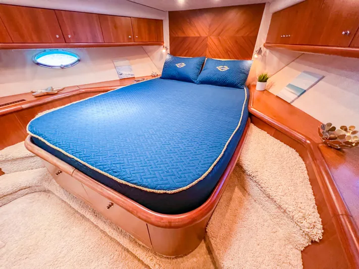  Yacht Photos Pics Luxurious 2005 Sunseeker Predator 68 yacht bedroom with blue bedding and wooden accents.