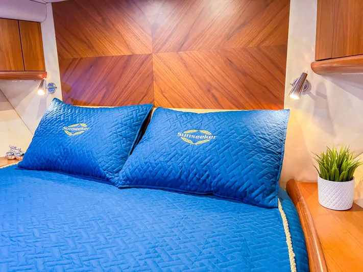  Yacht Photos Pics Luxurious Sunseeker Predator 68 yacht bedroom with blue bedding, wood accents, and modern lighting.