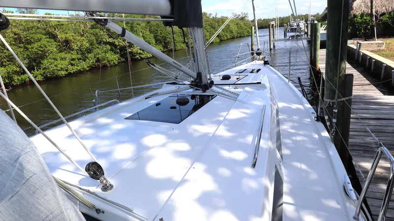 Wisp Yacht Photos Pics 2020 Hanse 388 yacht docked by a serene river with lush greenery.