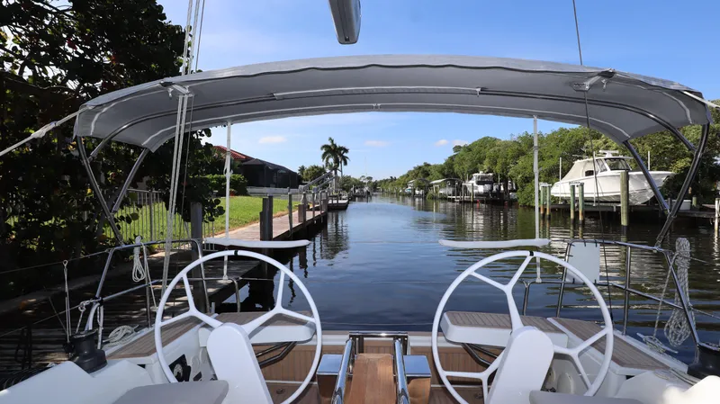 Wisp Yacht Photos Pics Sailing view from 2020 Hanse 388 yacht, featuring dual steering wheels and a scenic canal backdrop.