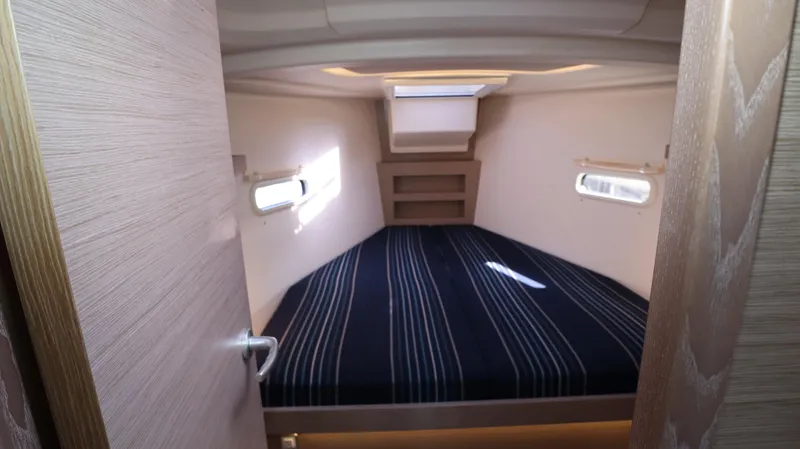 Wisp Yacht Photos Pics Cabin interior of 2020 Hanse 388 yacht with striped bedding and natural light.