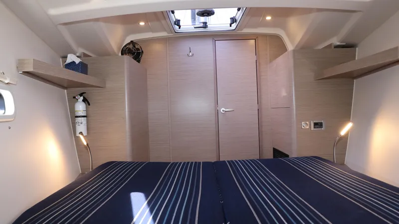 Wisp Yacht Photos Pics 2020 Hanse 388 yacht interior cabin with striped bedding and modern wood finish.
