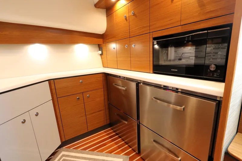 Lady K Yacht Photos Pics Modern kitchen in 2020 Tiara Yachts 43 Open, featuring wood cabinets and stainless steel appliances.