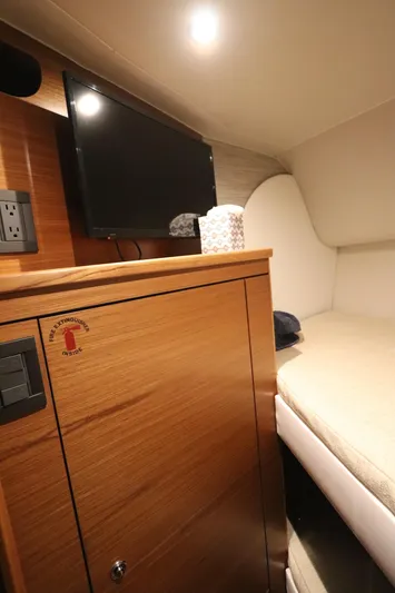 Lady K Yacht Photos Pics Interior cabin of 2020 Tiara Yachts 43 Open with TV and wooden cabinetry.